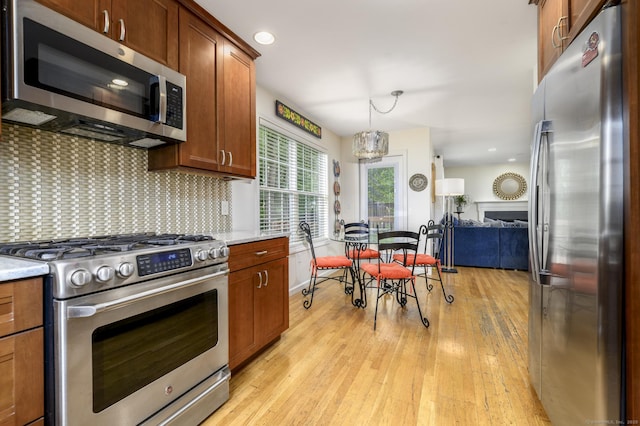 14 Linden Hts Unit 14, Norwalk, CT 06851 - kitchen with stainless steel appliances, light wood-style flooring, decorative backsplash, brown cabinets, and pendant lighting