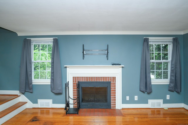 60 Old Mill Rd, Middletown, CT 06457 - unfurnished living room featuring a brick fireplace, healthy amount of natural light, ornamental molding, wood finished floors, and stairs