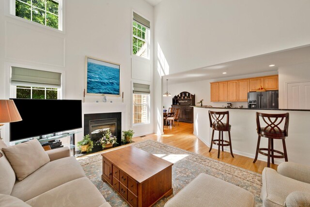 111 Thorn Hollow Rd, Cheshire, CT 06410 - living room featuring a high ceiling, light wood-style floors, recessed lighting, and a glass covered fireplace