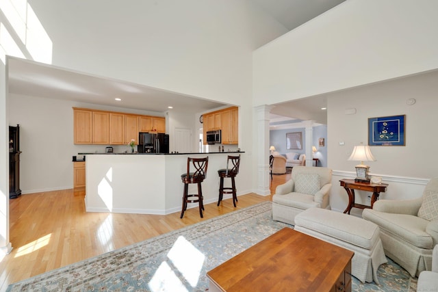 111 Thorn Hollow Rd, Cheshire, CT 06410 - living area with ornate columns, light wood-style floors, a high ceiling, baseboards, and recessed lighting
