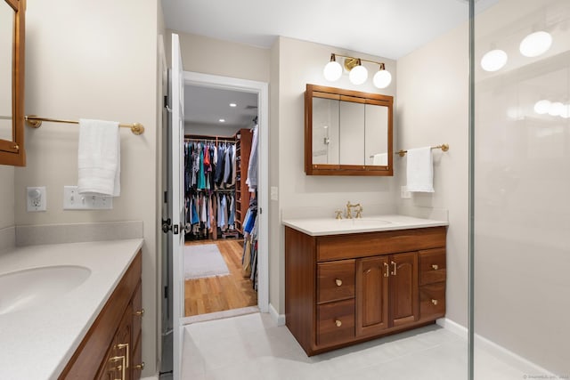 68 Mopus Bridge Rd, Ridgefield, CT 06877 - bathroom featuring two vanities, a walk in closet, tile patterned floors, and tiled shower
