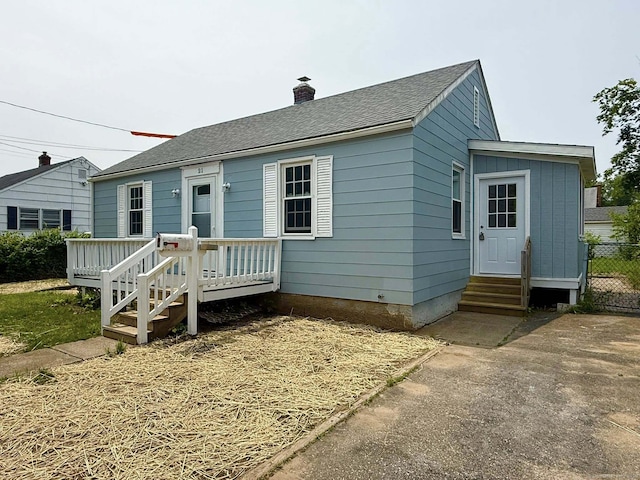 21 Lafayette Ave, East Hartford, CT 06118 - view of front of home with entry steps, a chimney, a wooden deck, and roof with shingles
