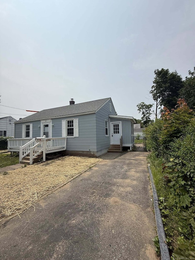 21 Lafayette Ave, East Hartford, CT 06118 - view of front facade with a deck, driveway, and a chimney