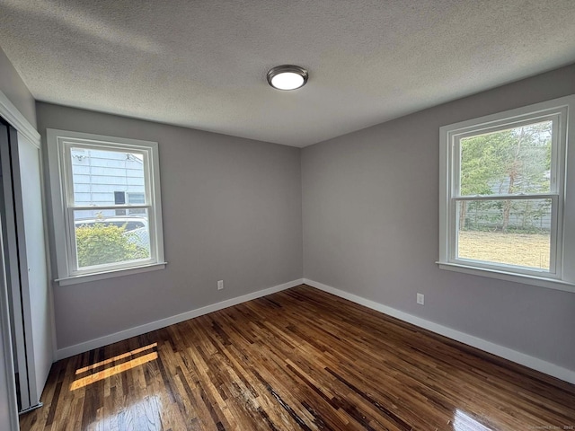 21 Lafayette Ave, East Hartford, CT 06118 - spare room featuring dark wood-style flooring, baseboards, and a textured ceiling