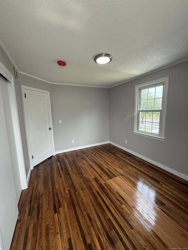 21 Lafayette Ave, East Hartford, CT 06118 - spare room with a textured ceiling, dark wood-type flooring, crown molding, and baseboards