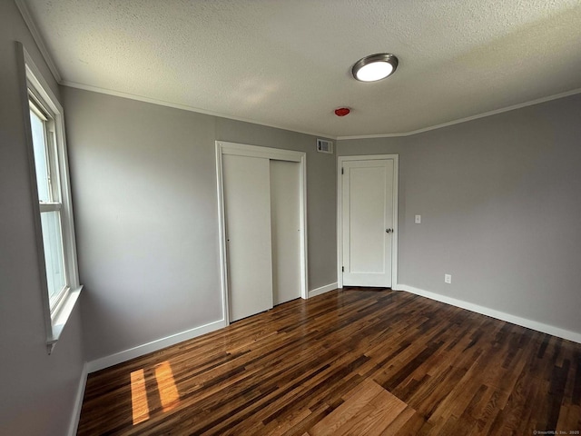 21 Lafayette Ave, East Hartford, CT 06118 - unfurnished bedroom featuring dark wood-style flooring, a textured ceiling, ornamental molding, a closet, and baseboards