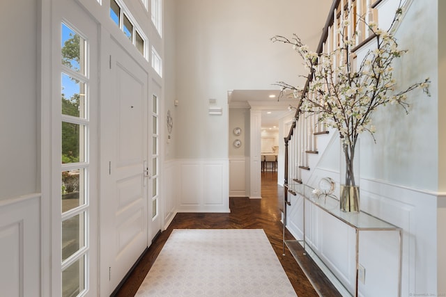 133 Buttery Rd, New Canaan, CT 06840 - entrance foyer with a towering ceiling, stairway, wainscoting, a decorative wall, and crown molding