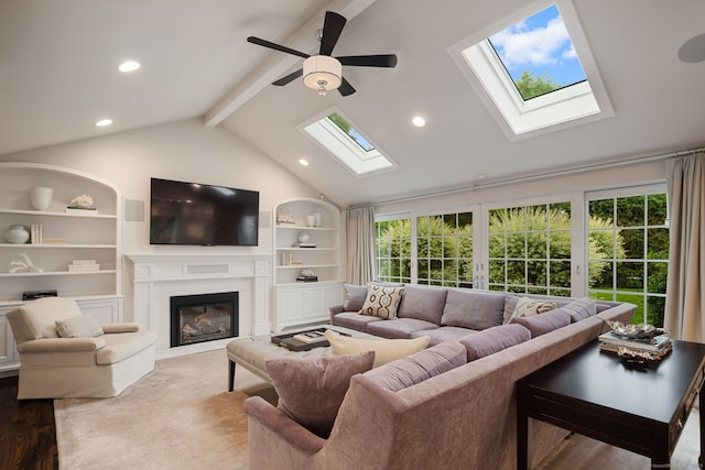 133 Buttery Rd, New Canaan, CT 06840 - living room featuring a skylight, a glass covered fireplace, beam ceiling, ceiling fan, and built in features