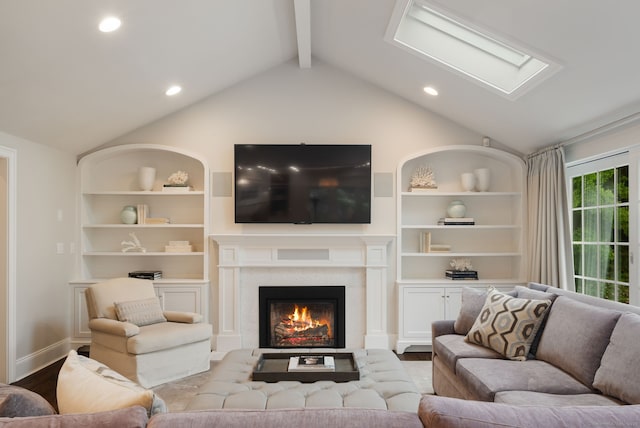 133 Buttery Rd, New Canaan, CT 06840 - living room featuring wood finished floors, a glass covered fireplace, built in shelves, a skylight, and recessed lighting