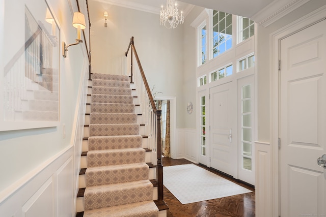 133 Buttery Rd, New Canaan, CT 06840 - entrance foyer featuring stairs, a decorative wall, wainscoting, ornamental molding, and a chandelier