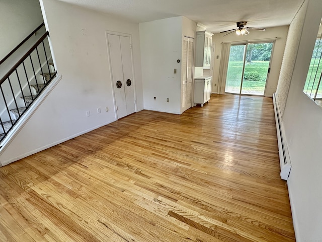 24 Woodward Ave Apt 19, New Haven, CT 06512 - unfurnished living room featuring light wood-style floors, ceiling fan, stairway, and baseboard heating