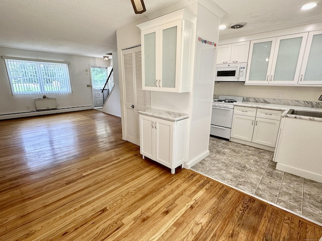 24 Woodward Ave Apt 19, New Haven, CT 06512 - kitchen featuring white appliances, white cabinets, light wood-style floors, a baseboard radiator, and open floor plan