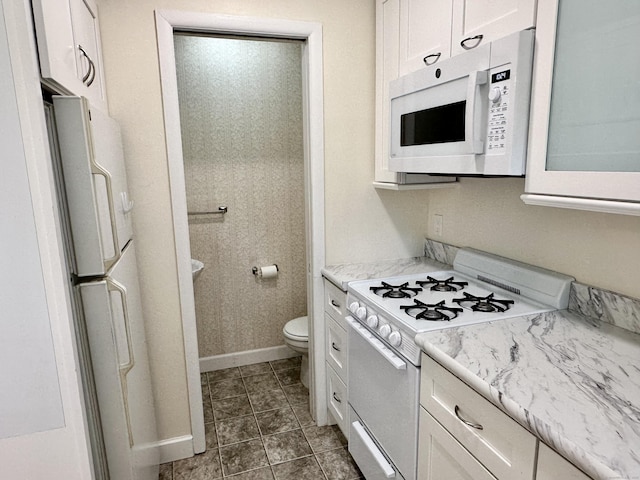 24 Woodward Ave Apt 19, New Haven, CT 06512 - kitchen featuring white appliances, white cabinetry, and dark tile patterned flooring
