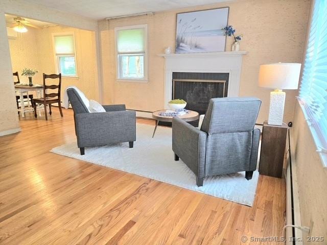 20 Kimball Rd, Wethersfield, CT 06109 - living room featuring wood finished floors, a fireplace, ceiling fan, and a baseboard heating unit