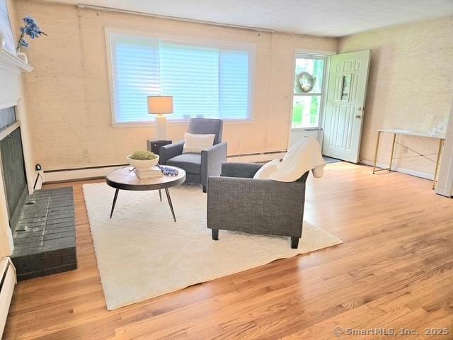 20 Kimball Rd, Wethersfield, CT 06109 - living room with a baseboard radiator, wood finished floors, and a brick fireplace