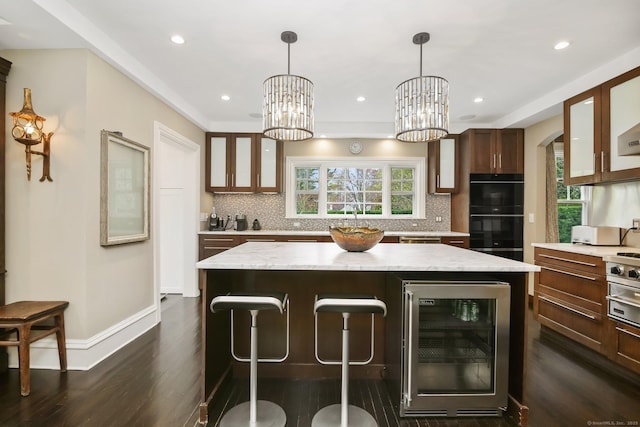 11 Old Hill Rd, Westport, CT 06880 - kitchen featuring wine cooler, dark wood-style floors, a center island, decorative backsplash, and a breakfast bar area