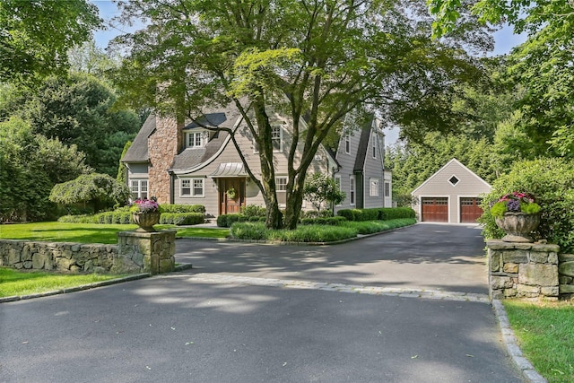11 Old Hill Rd, Westport, CT 06880 - view of front facade featuring a garage, an outbuilding, and a chimney
