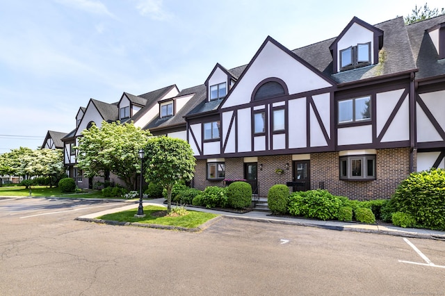 668 Glenbrook Rd Unit 9, Stamford, CT 06906 - view of front of house featuring stucco siding, uncovered parking, brick siding, and a shingled roof