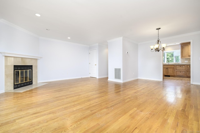668 Glenbrook Rd Unit 9, Stamford, CT 06906 - unfurnished living room with a tiled fireplace, light wood-style floors, a chandelier, baseboards, and ornamental molding