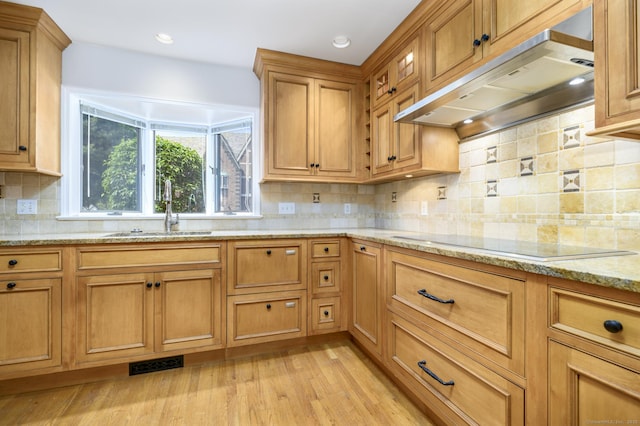 668 Glenbrook Rd Unit 9, Stamford, CT 06906 - kitchen with under cabinet range hood, a sink, black electric cooktop, light wood-style floors, and light stone countertops