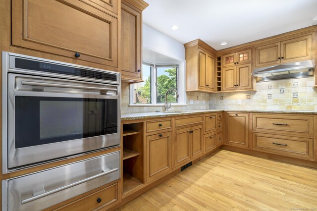 668 Glenbrook Rd Unit 9, Stamford, CT 06906 - kitchen featuring oven, a sink, under cabinet range hood, a warming drawer, and light wood-style floors
