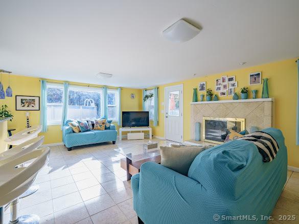 847 Glenbrook Rd, Orange, CT 06477 - tiled living room featuring a glass covered fireplace and baseboards