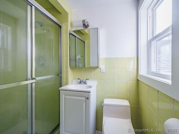 847 Glenbrook Rd, Orange, CT 06477 - bathroom featuring vanity, a shower stall, and tile walls
