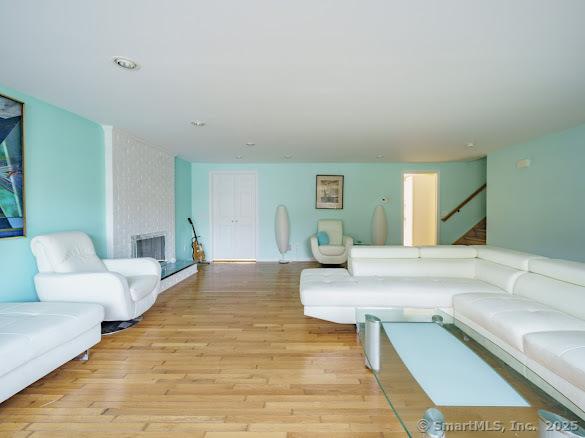 847 Glenbrook Rd, Orange, CT 06477 - living room featuring stairway, light wood-style floors, and a large fireplace