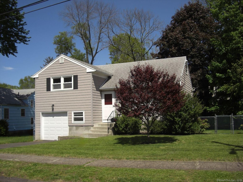 54 Bates St, Hartford, CT 06114 - view of front facade with roof with shingles, an attached garage, and asphalt driveway
