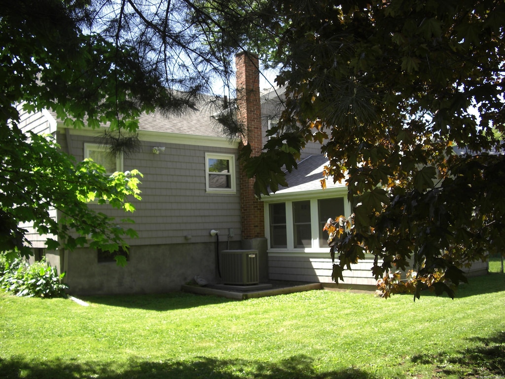 54 Bates St, Hartford, CT 06114 - rear view of house with a chimney, a yard, and roof with shingles