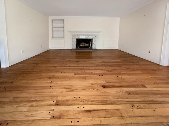 206 Peddlers Rd, Guilford, CT 06437 - unfurnished living room featuring hardwood / wood-style flooring, built in shelves, and a fireplace