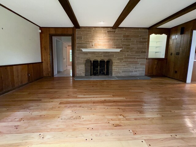 206 Peddlers Rd, Guilford, CT 06437 - unfurnished living room with wood walls, beam ceiling, wood-type flooring, and a stone fireplace