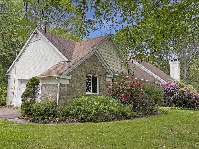 206 Peddlers Rd, Guilford, CT 06437 - view of side of property featuring stone siding, a lawn, a chimney, and a shingled roof
