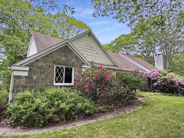 206 Peddlers Rd, Guilford, CT 06437 - view of side of home with stone siding, a chimney, and a yard