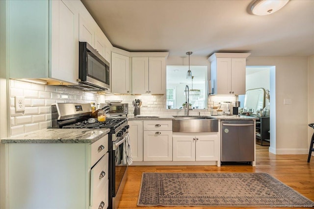 60 Davenport Rd, West Hartford, CT 06110 - kitchen with stainless steel appliances, decorative backsplash, white cabinets, and light stone countertops