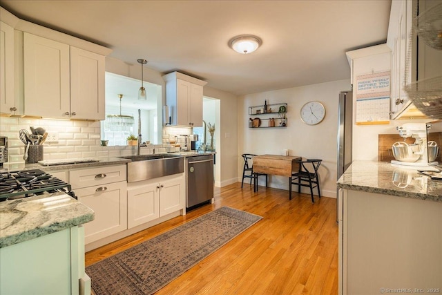 60 Davenport Rd, West Hartford, CT 06110 - kitchen with dishwasher, decorative backsplash, white cabinetry, light wood-style floors, and hanging light fixtures