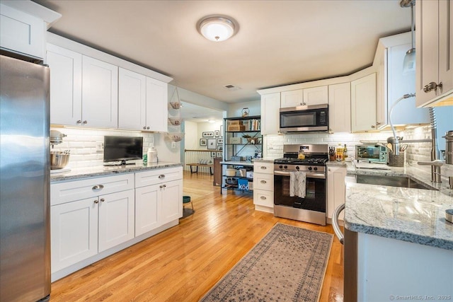 60 Davenport Rd, West Hartford, CT 06110 - kitchen with appliances with stainless steel finishes, decorative backsplash, white cabinetry, light wood finished floors, and light stone countertops