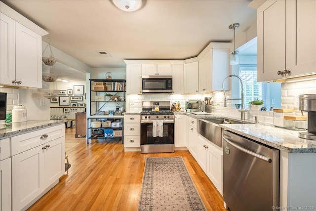 60 Davenport Rd, West Hartford, CT 06110 - kitchen with appliances with stainless steel finishes, decorative backsplash, pendant lighting, and white cabinets
