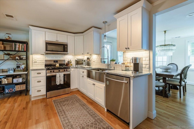 60 Davenport Rd, West Hartford, CT 06110 - kitchen with stainless steel appliances, decorative backsplash, white cabinets, and light wood finished floors