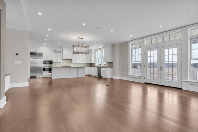 66 High St Unit 36, Guilford, CT 06437 - unfurnished living room featuring recessed lighting, a chandelier, dark wood-style floors, baseboards, and french doors