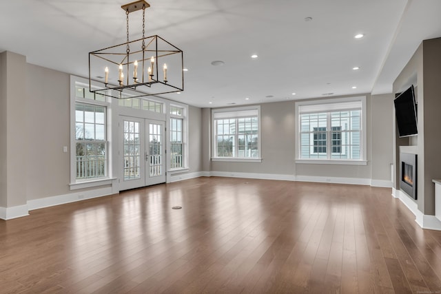 66 High St Unit 36, Guilford, CT 06437 - unfurnished living room with a glass covered fireplace, wood finished floors, baseboards, a chandelier, and recessed lighting