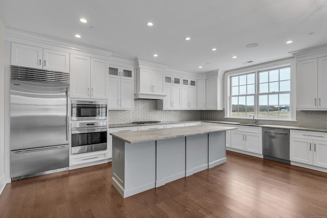 66 High St Unit 36, Guilford, CT 06437 - kitchen featuring stainless steel appliances, backsplash, white cabinets, a kitchen island, and light stone countertops