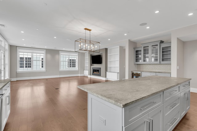 66 High St Unit 36, Guilford, CT 06437 - kitchen with wine cooler, wood finished floors, baseboards, light countertops, and a kitchen island