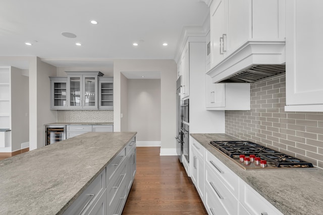 66 High St Unit 36, Guilford, CT 06437 - kitchen with appliances with stainless steel finishes, beverage cooler, baseboards, light stone countertops, and decorative backsplash