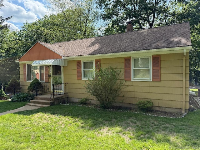 19 Benedict St, Plymouth, CT 06786 - view of front of property with a chimney, a shingled roof, and a front yard