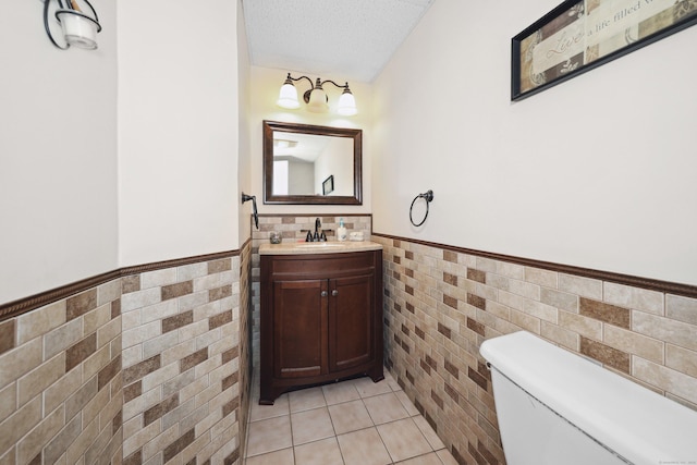 19 Benedict St, Plymouth, CT 06786 - bathroom featuring tile walls, a wainscoted wall, vanity, tile patterned flooring, and a textured ceiling