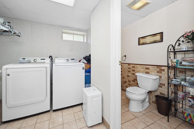 19 Benedict St, Plymouth, CT 06786 - laundry area featuring washer and clothes dryer, light tile patterned floors, a wainscoted wall, and tile walls