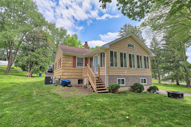 19 Benedict St, Plymouth, CT 06786 - rear view of house featuring a chimney, a sunroom, a lawn, and stairs