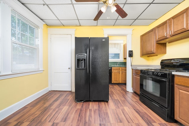43 Quentin St, Hamden, CT 06517 - kitchen with black appliances, a drop ceiling, ceiling fan, dark wood-style floors, and brown cabinetry