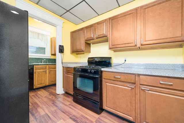 43 Quentin St, Hamden, CT 06517 - kitchen with black appliances, light countertops, a drop ceiling, wood finished floors, and brown cabinets